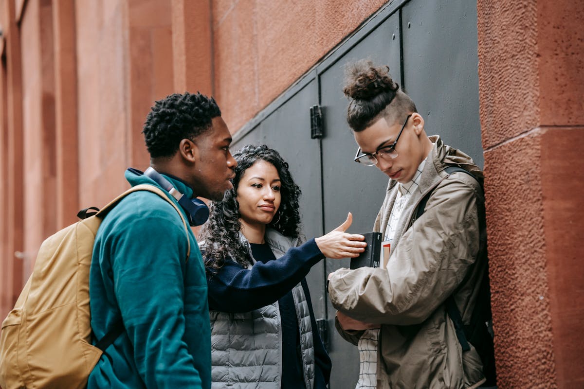 Multiethnic students bullying guy on street