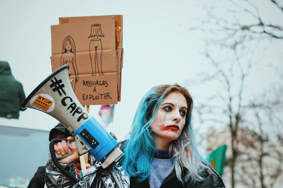 Young woman with painted face and megaphone during sexual exploitation protest